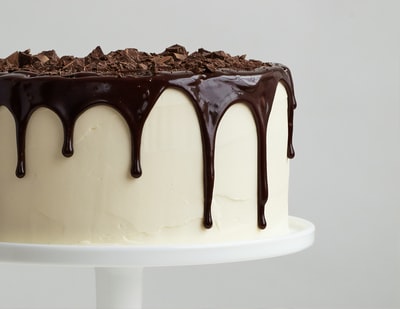 白色陶瓷盘上有巧克力糖浆的白色蛋糕